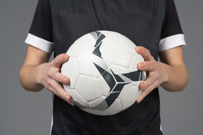 Close-up of a soccer player holding a ball
