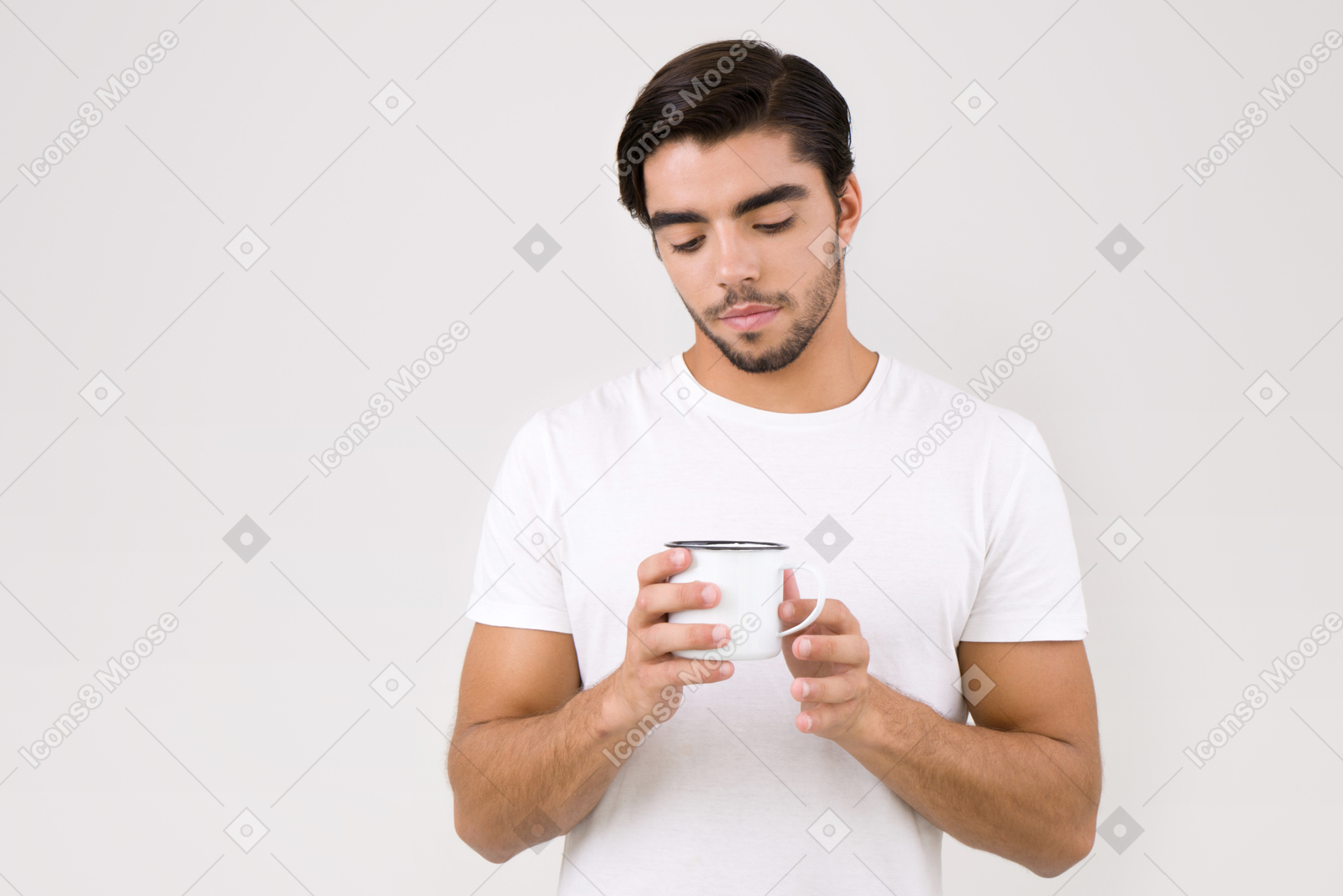 Handsome young man holding an enamel mug