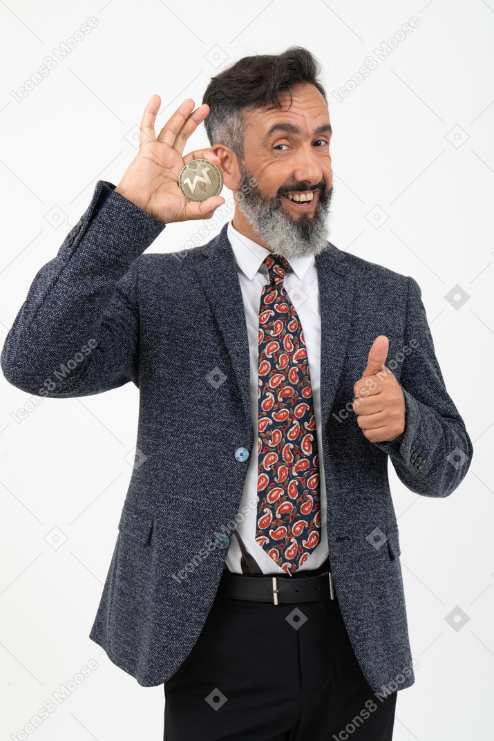 Mature man holding a monero coin and showing a thumb up