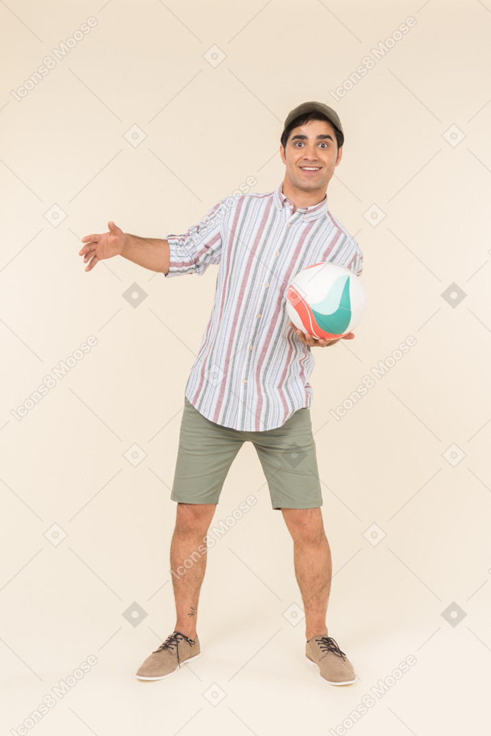 Surprised young caucasian guy holding ball