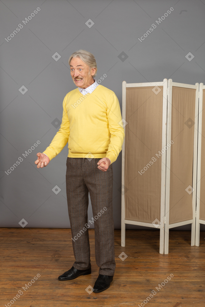 Vista de tres cuartos de un anciano impaciente apretando los puños