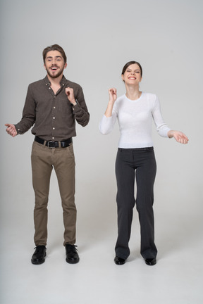 Front view of a delighted young couple in office clothing