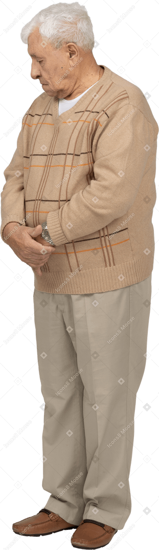 Front view of an old man in casual clothes looking down