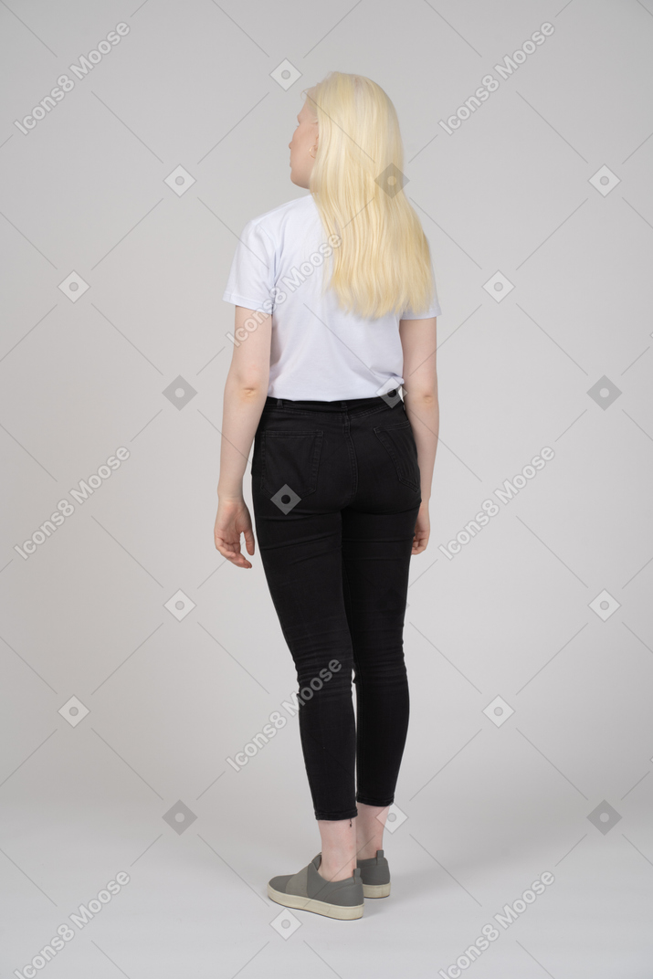 Three-quarter back view of a young woman in casual clothes looking away