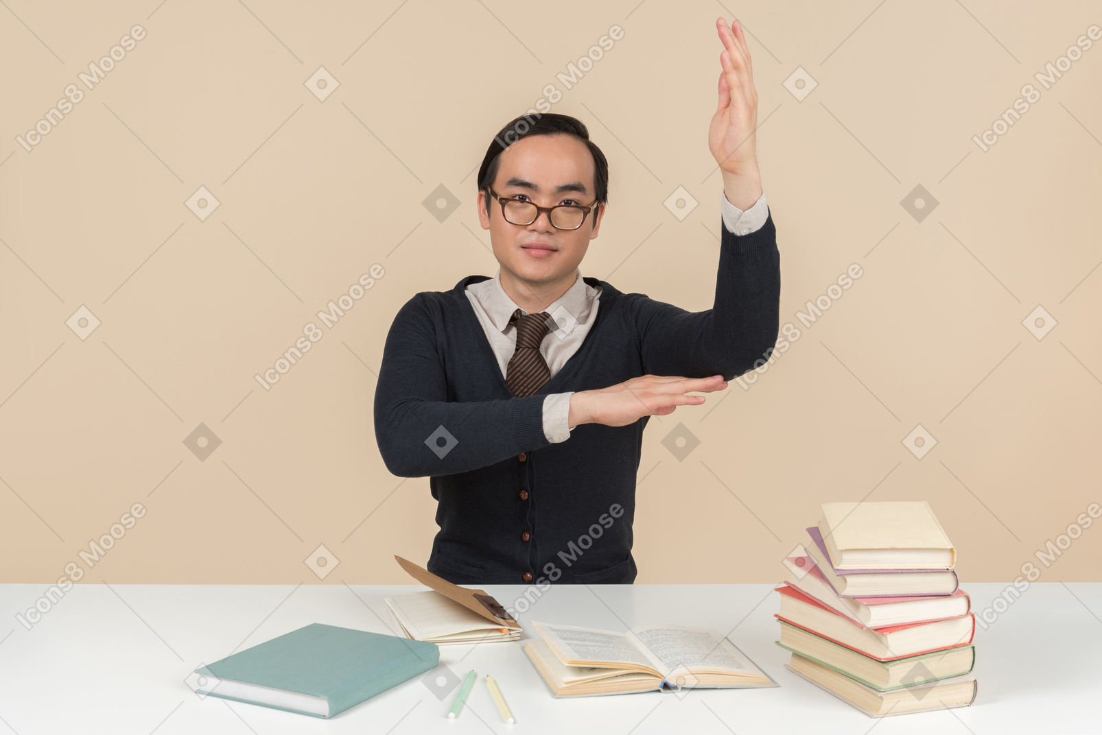 Young asian student in a sweater raising his hand
