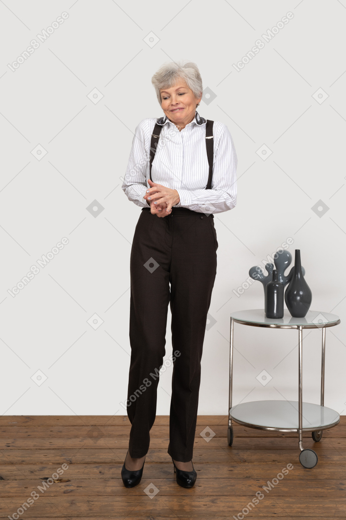 Vista frontal de uma senhora perplexa com roupas de escritório, de mãos dadas