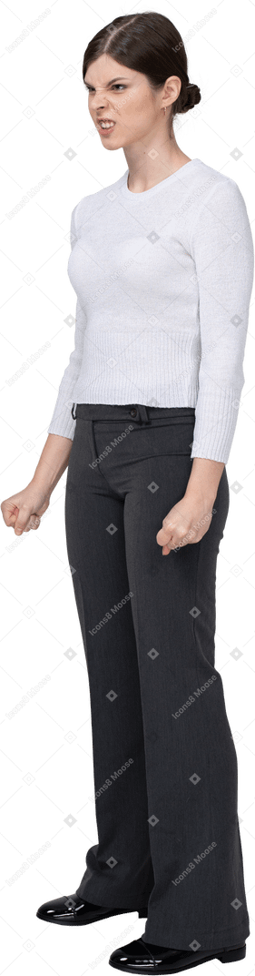 Трехчетвертный вид разъяренной женщины в офисной одежде, сжимающей кулаки