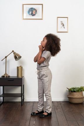 Good looking girl kid posing on the apartment background