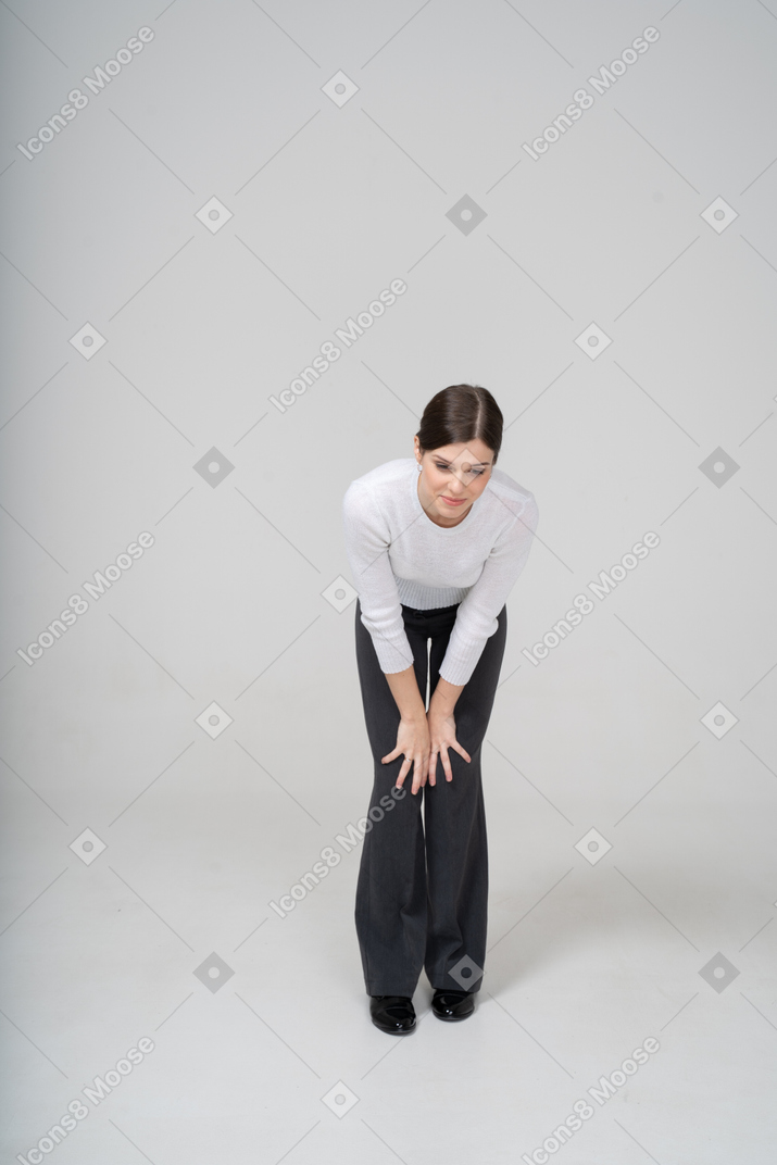 Front view of a woman in suit bending down