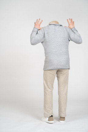 Man raising his hands standing with his back toward the camera