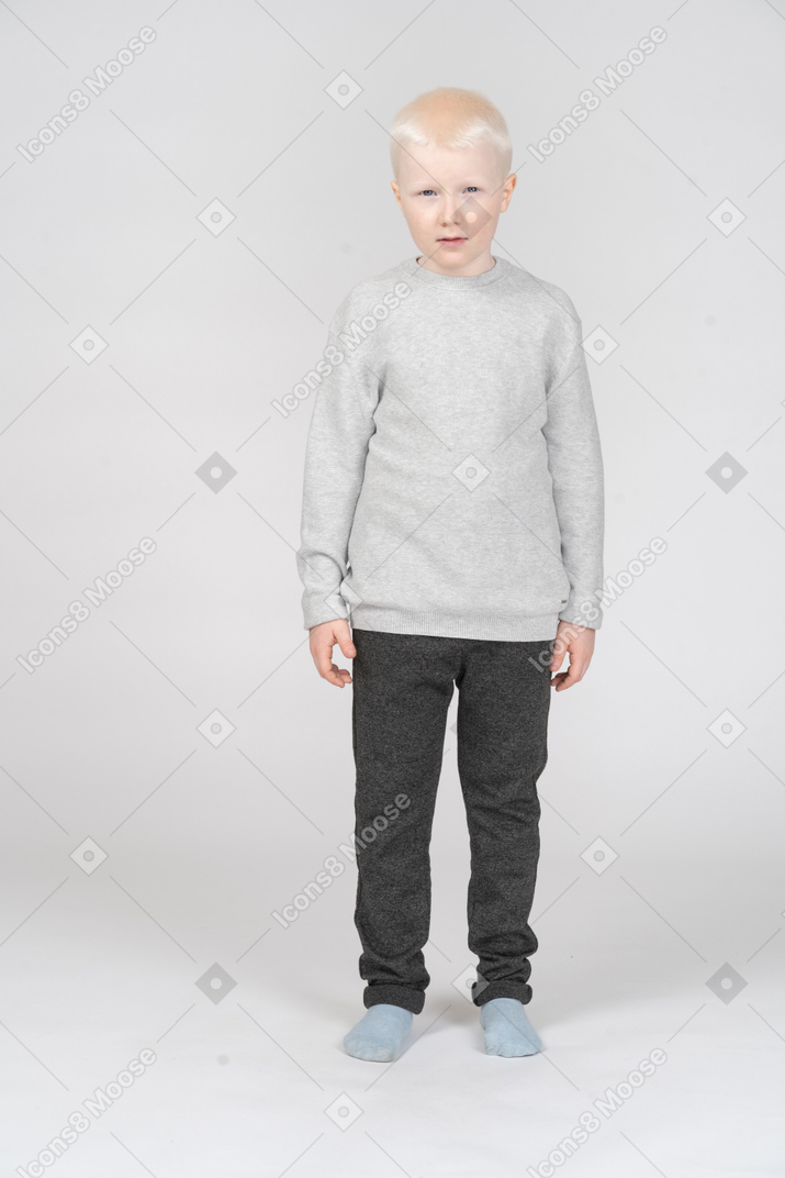 Front view of an offended kid boy looking at camera