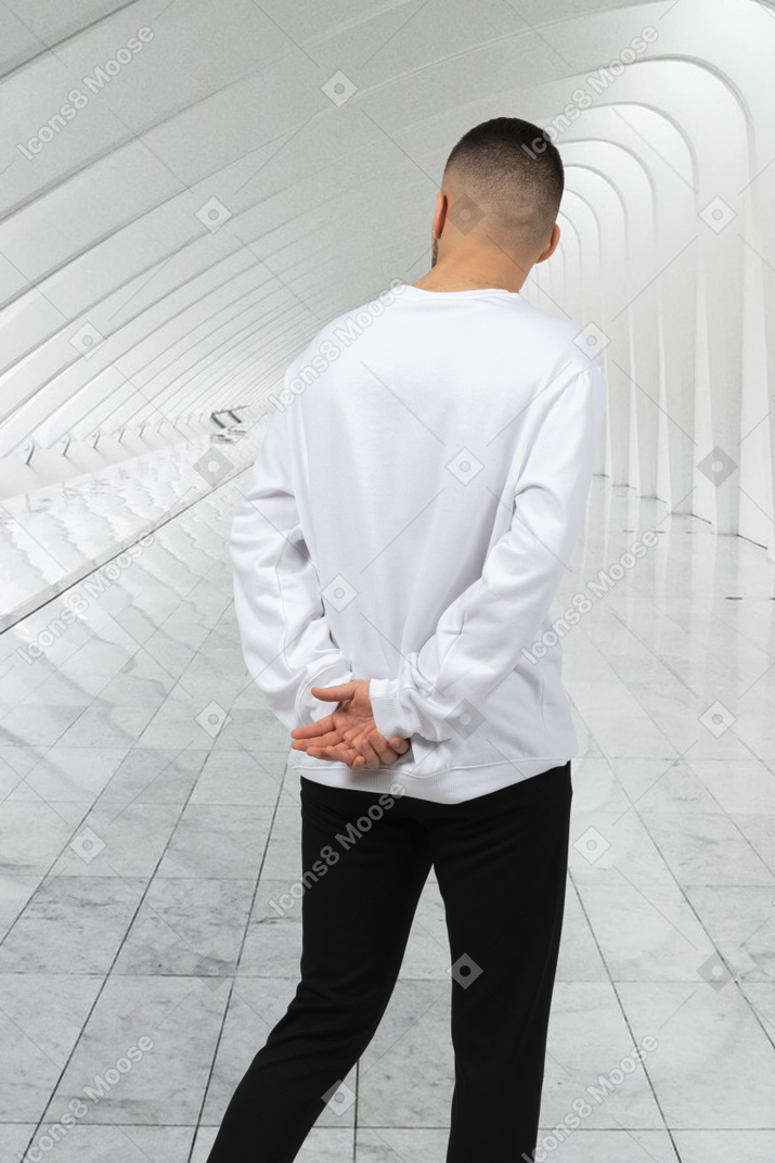 Back view of a man in a white shirt and black pants