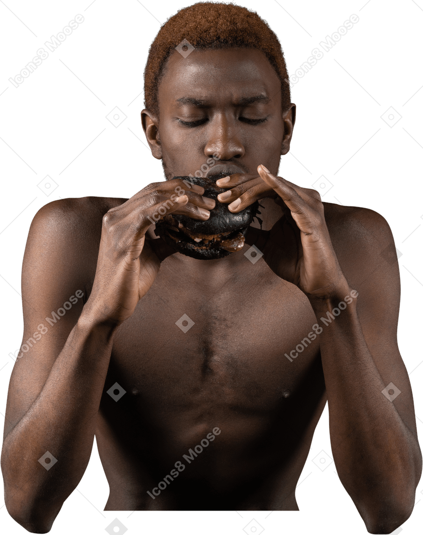 Vista frontale di un giovane afro che mangia un hamburger