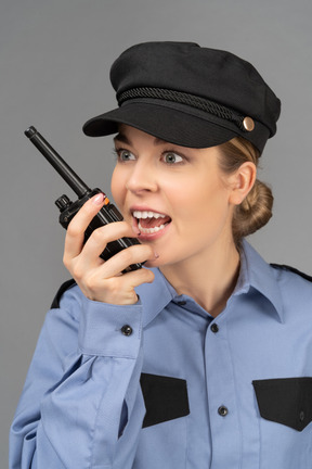 Guardia de seguridad femenina hablando por radio