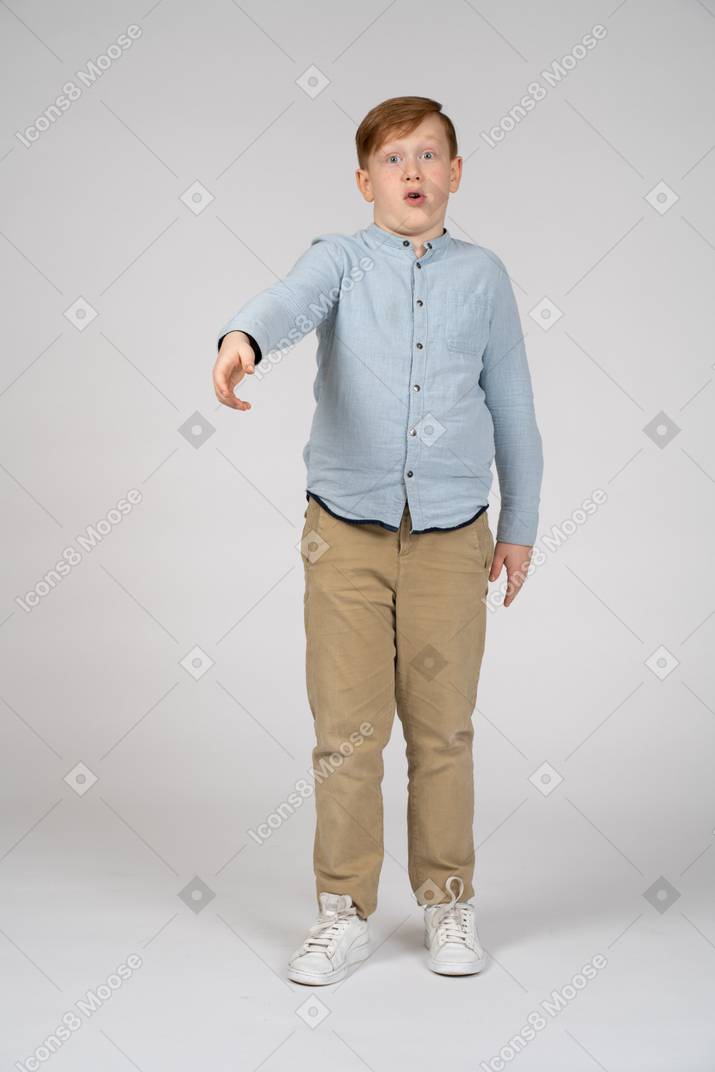 一个男孩站着伸出手臂，看着相机的正面图