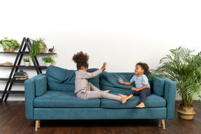 Good looking boy and girl play on the sofa