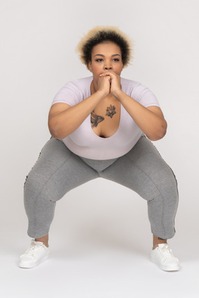 Plus size dark skinned female squatting with wrist-lock grip