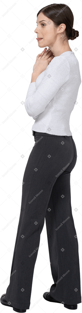 Three-quarter back view of a young woman in office clothing licking lips