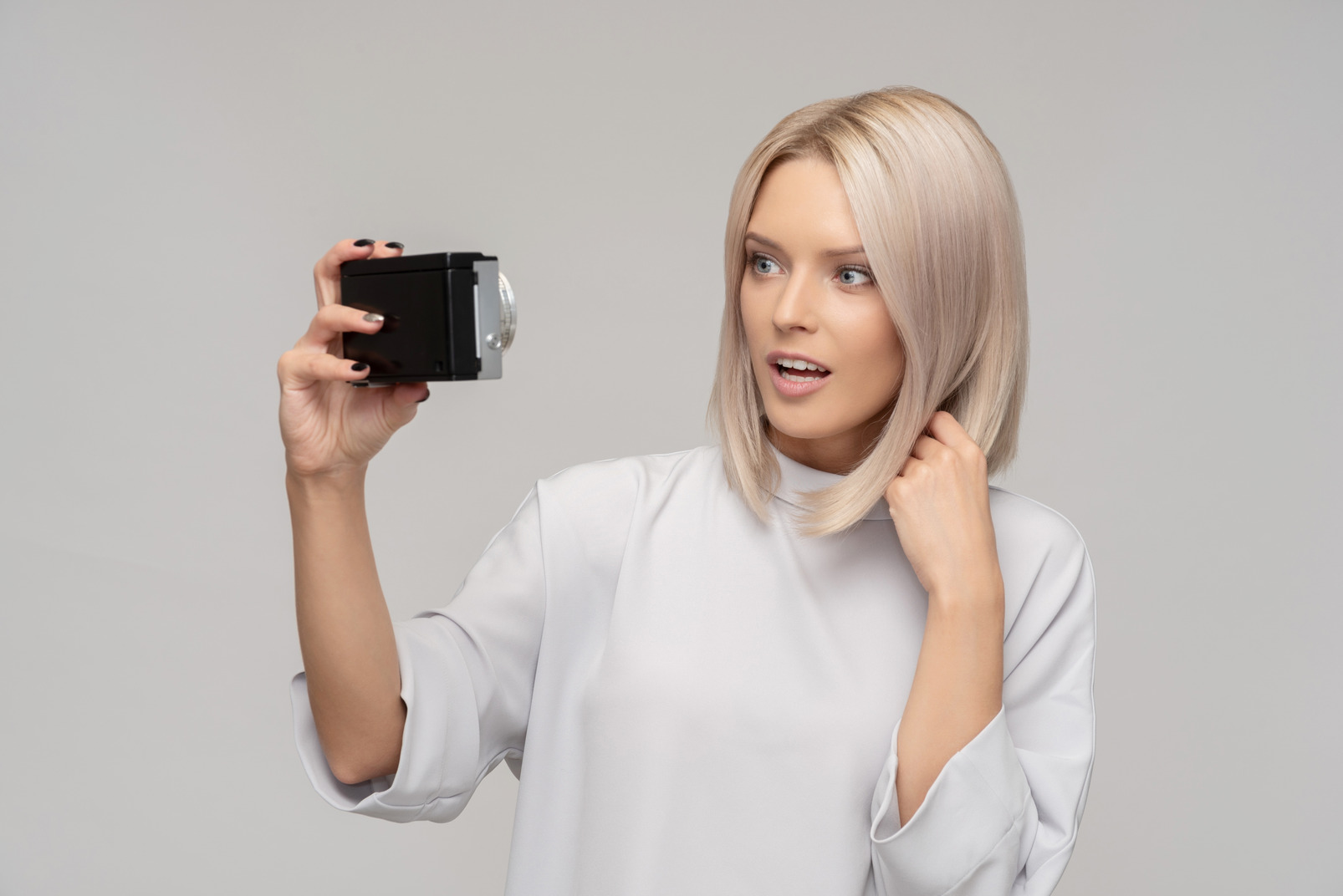Surprised  woman taking a selfie with an old camera