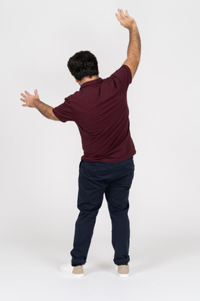 A young man raising his arms with his back to the camera