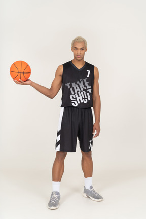 Vue de face d'un jeune joueur de basket-ball masculin tenant un ballon