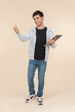 Jovem homem caucasiano segurando um tablet digital