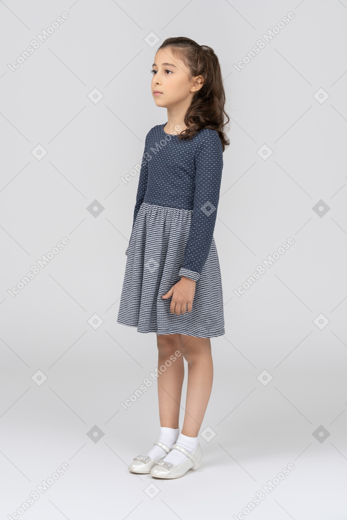 Vista frontal de uma garota em pé com os braços nas laterais