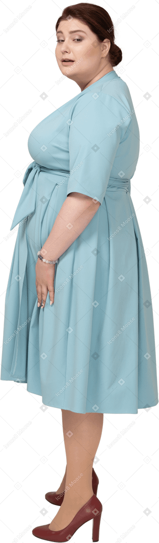Woman in blue dress posing in profile