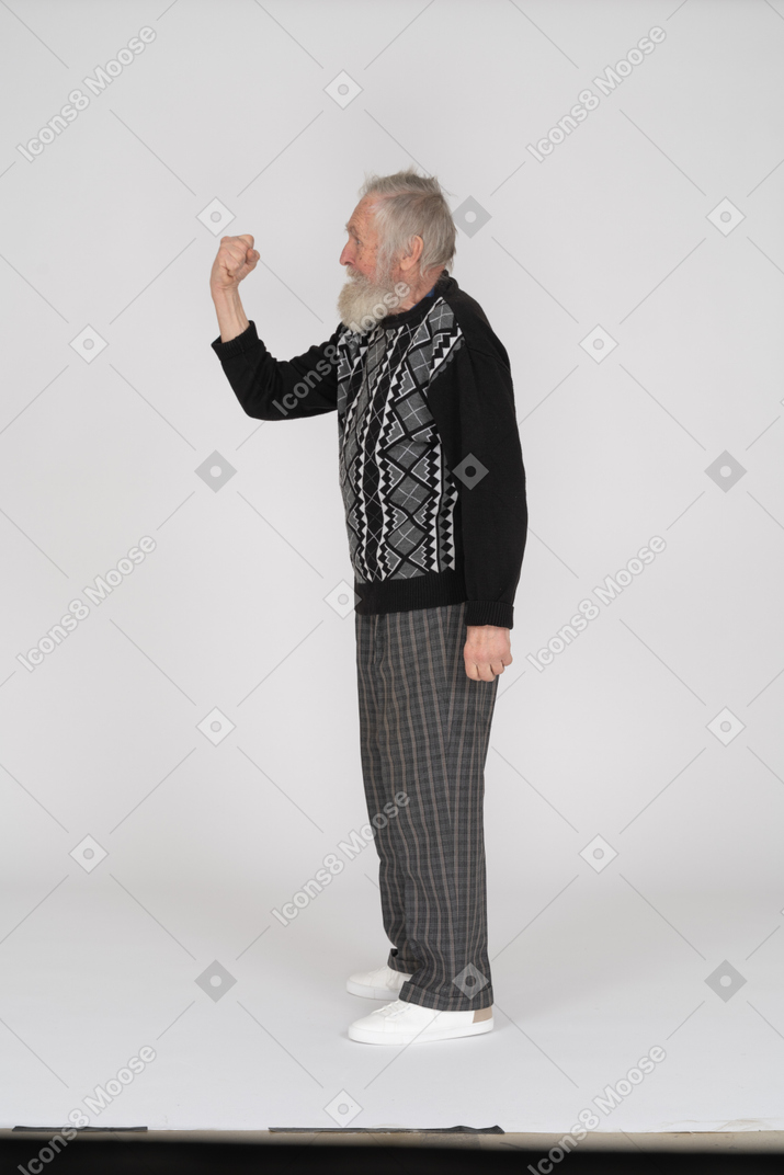 Side view of old man threatening with clenched fist