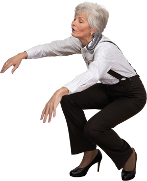 Three-quarter view of a squatting old lady outstretching her hands