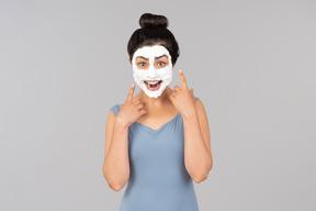 Excited looking woman with white facial mask on