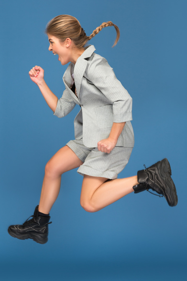 Excited young woman making a yeah gesture in a jump