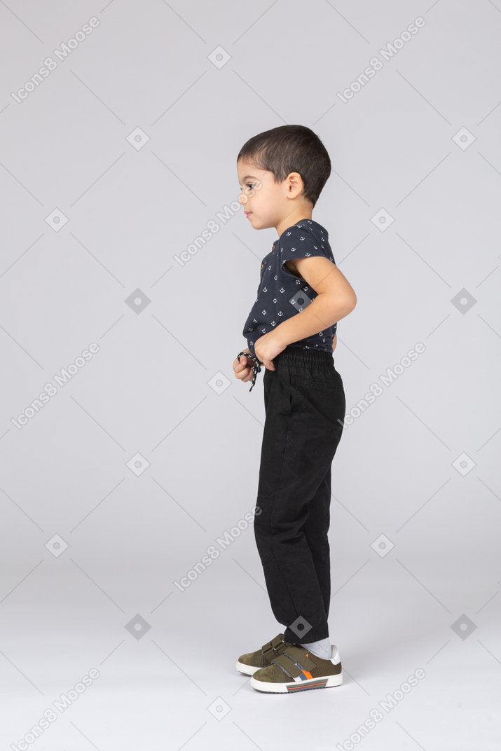 Cute boy in casual clothes standing in profile