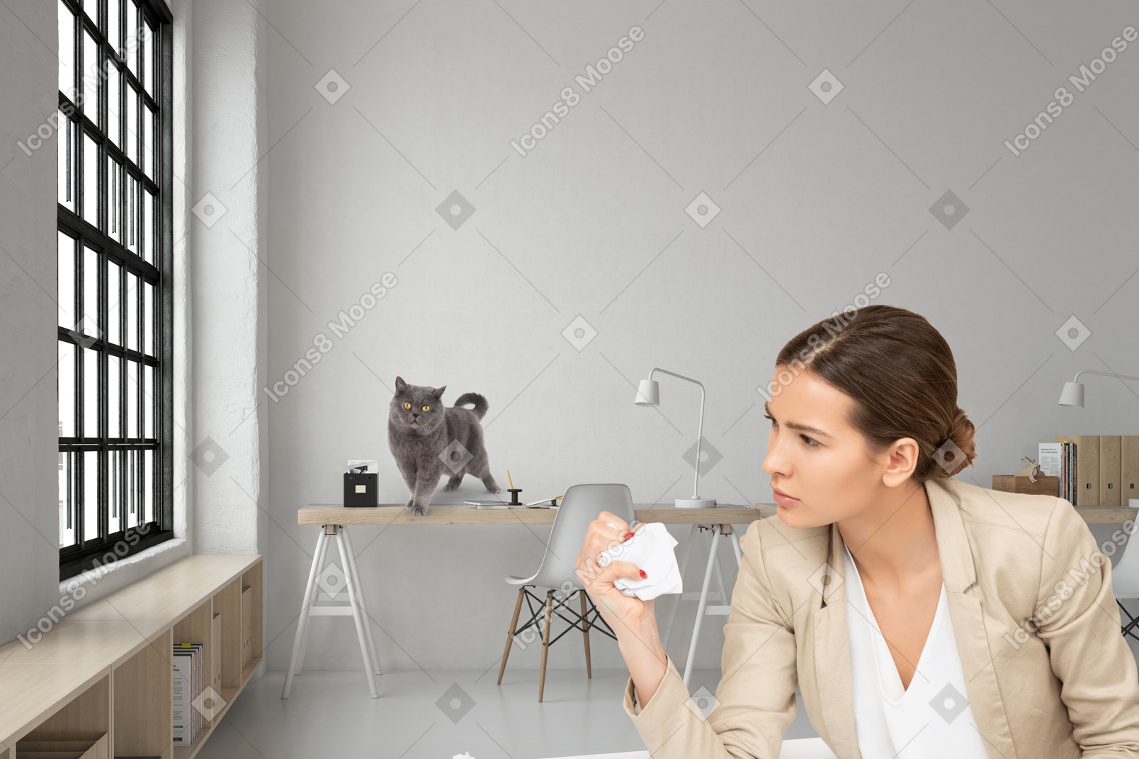 A woman sitting at a desk with a cat in the background
