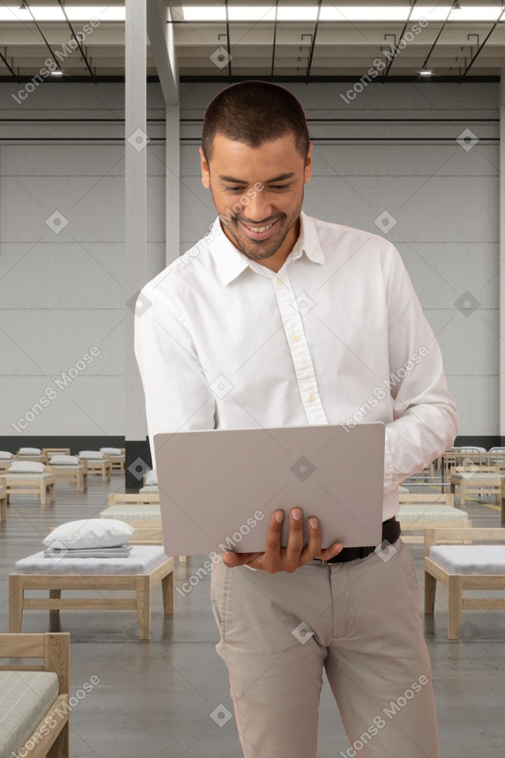 A man in a white shirt is using a laptop