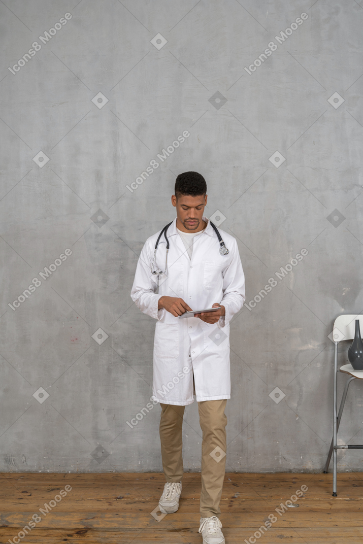 Medico maschio che cammina verso la telecamera