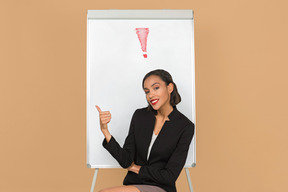 Attractive afro woman sitting by the whiteboard