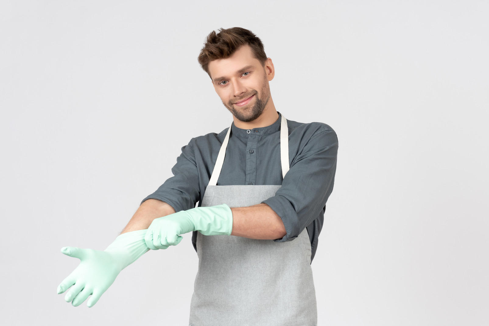 Young househusband putting on gloves