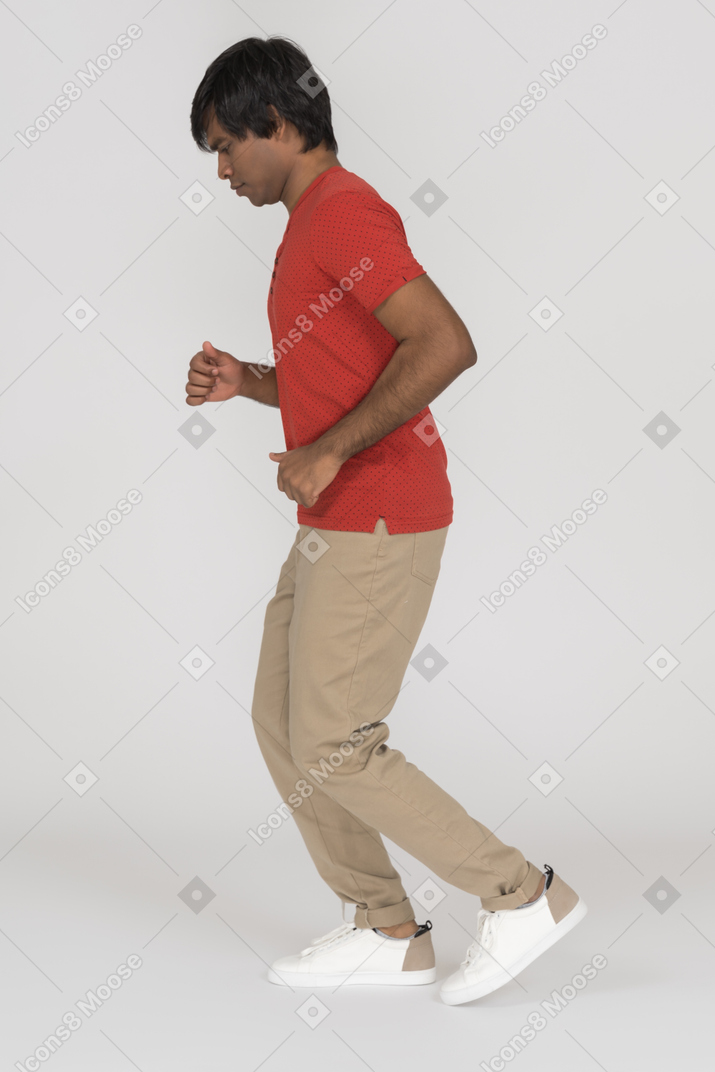 Side view of young man jogging