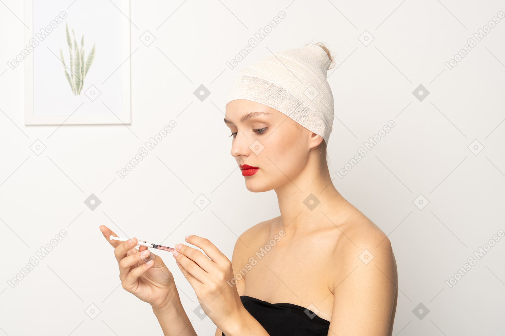 注射器を保持している包帯の頭を持つ若い女性