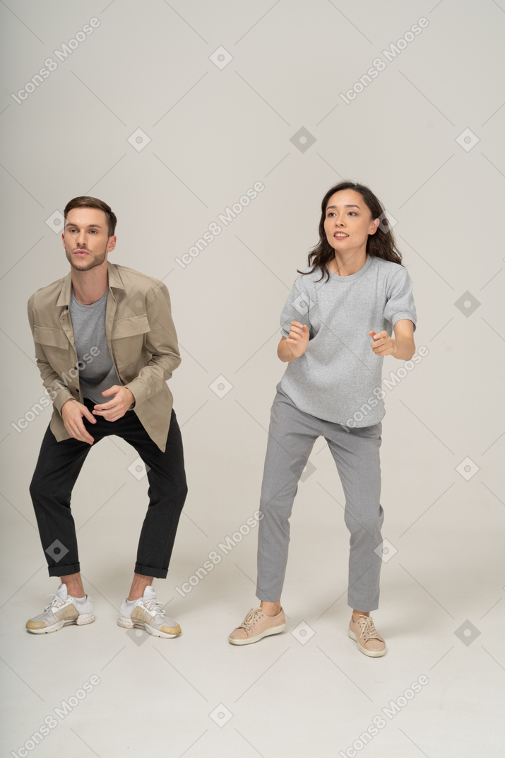 Man and woman doing a dance move side by side