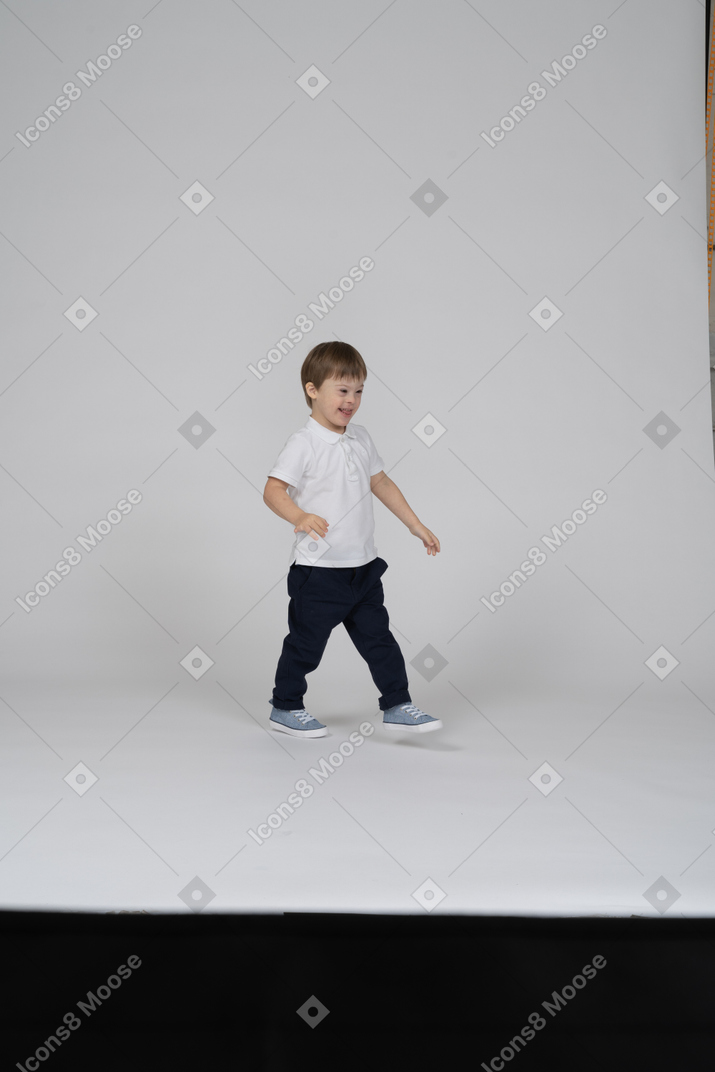 Улыбающийся маленький мальчик ходит
