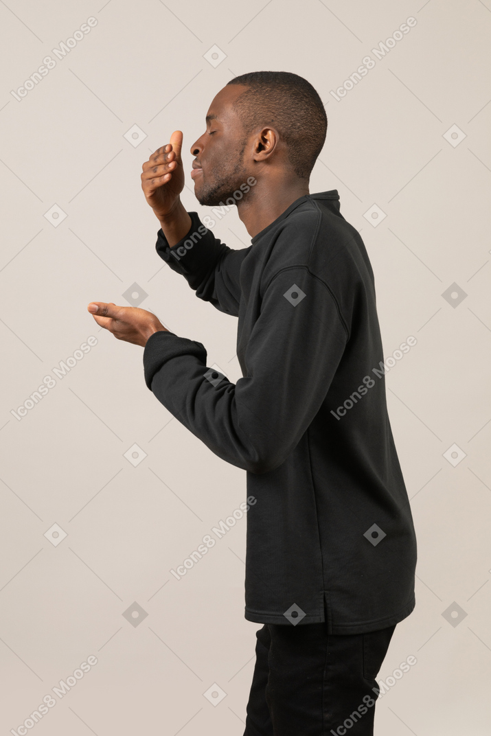 Side view of a man actively smelling something