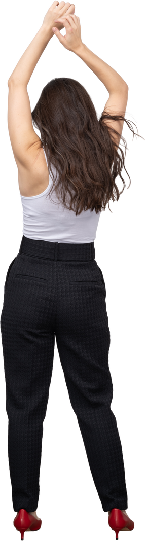 Vista traseira de uma jovem mulher com roupa de escritório, levantando as mãos na cabeça