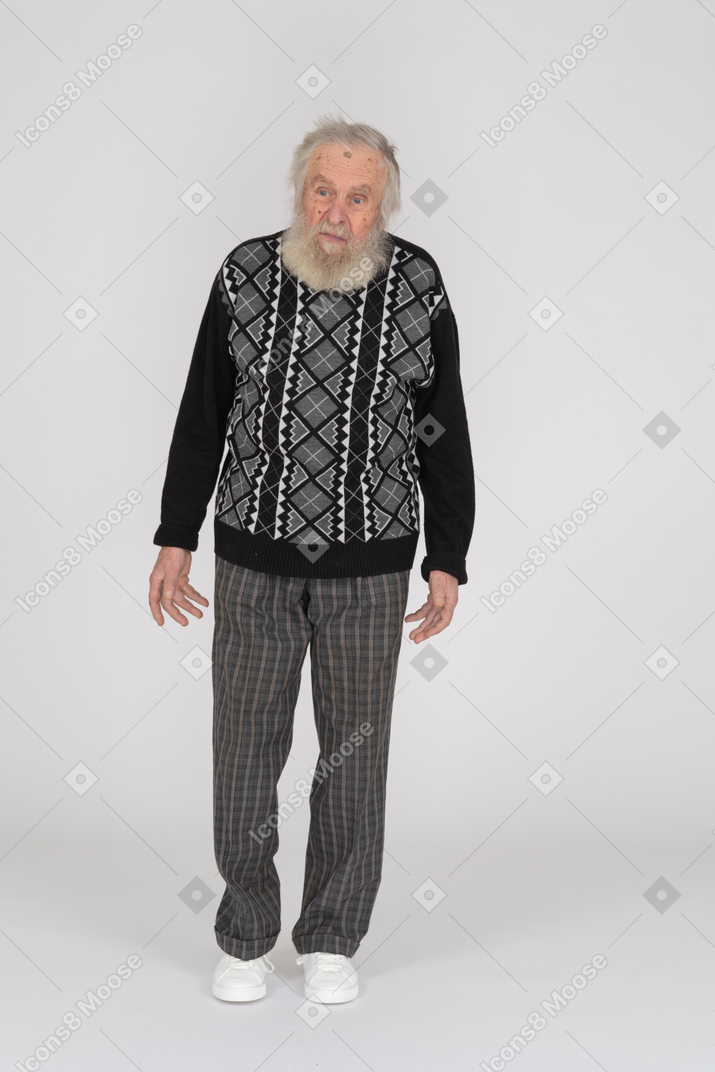 腕を脇に置いて立っている年配の男性の正面図