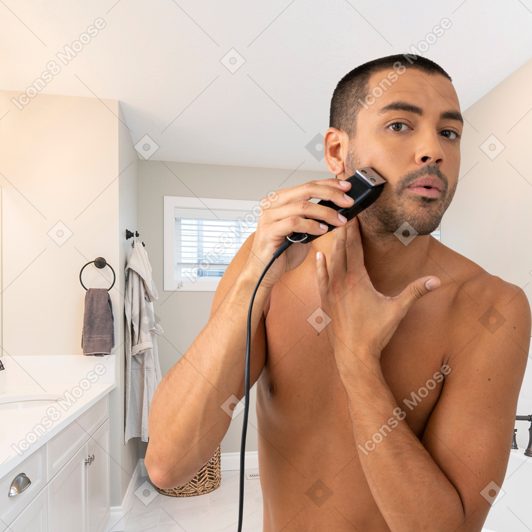 Man shaving his beard in the bathroom