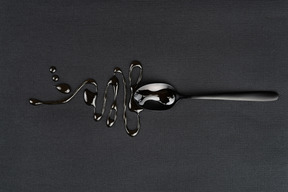 Tea spoon with liquid on the black