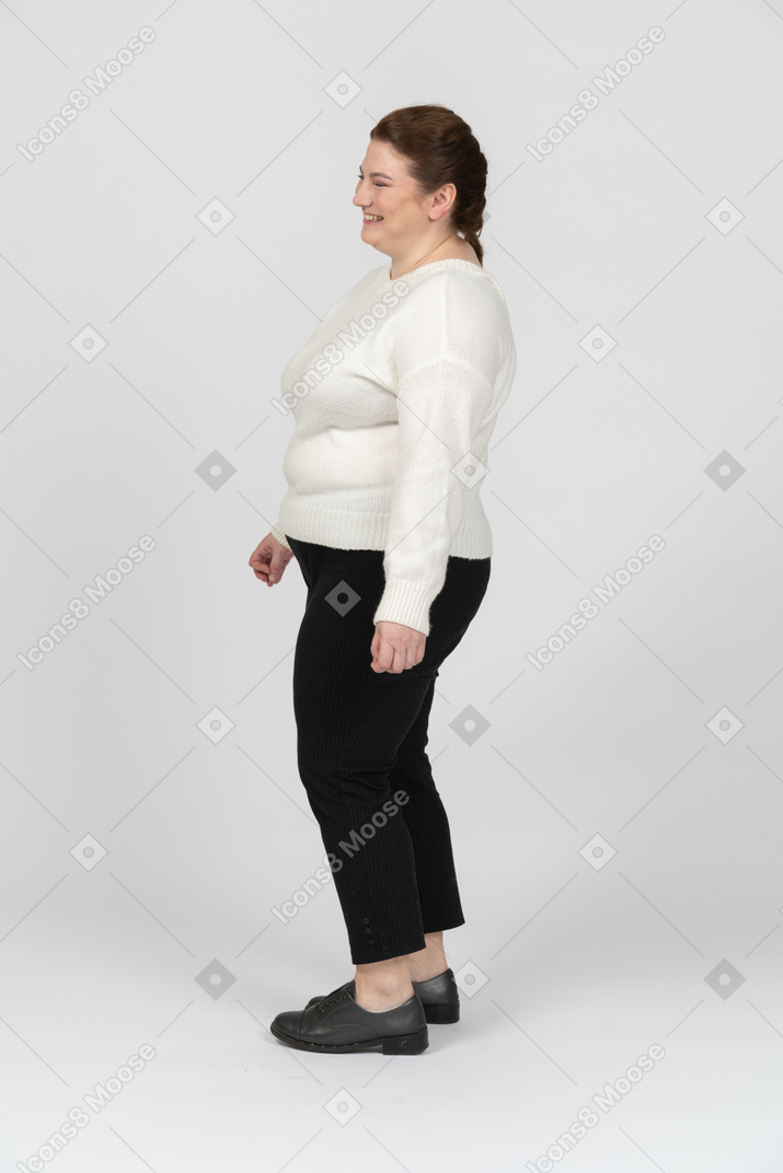 Happy plus size woman standing in profile
