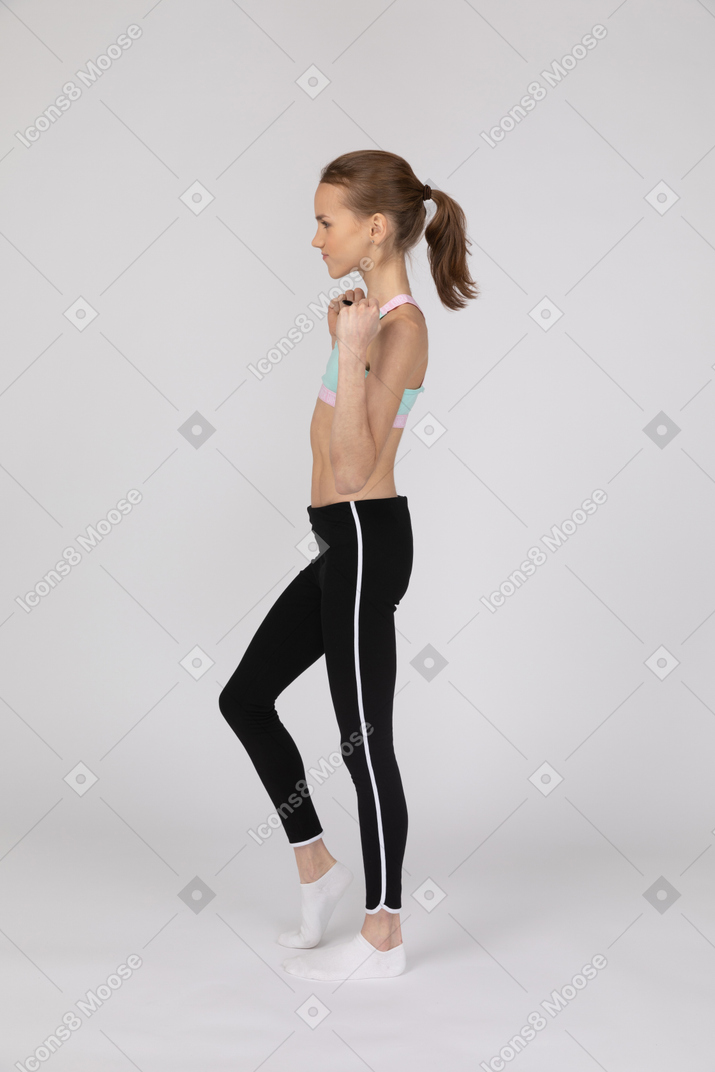 Side view of teen girl with clenched fists