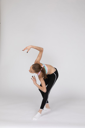 Three-quarter view of a teen girl in sportswear leaning forward